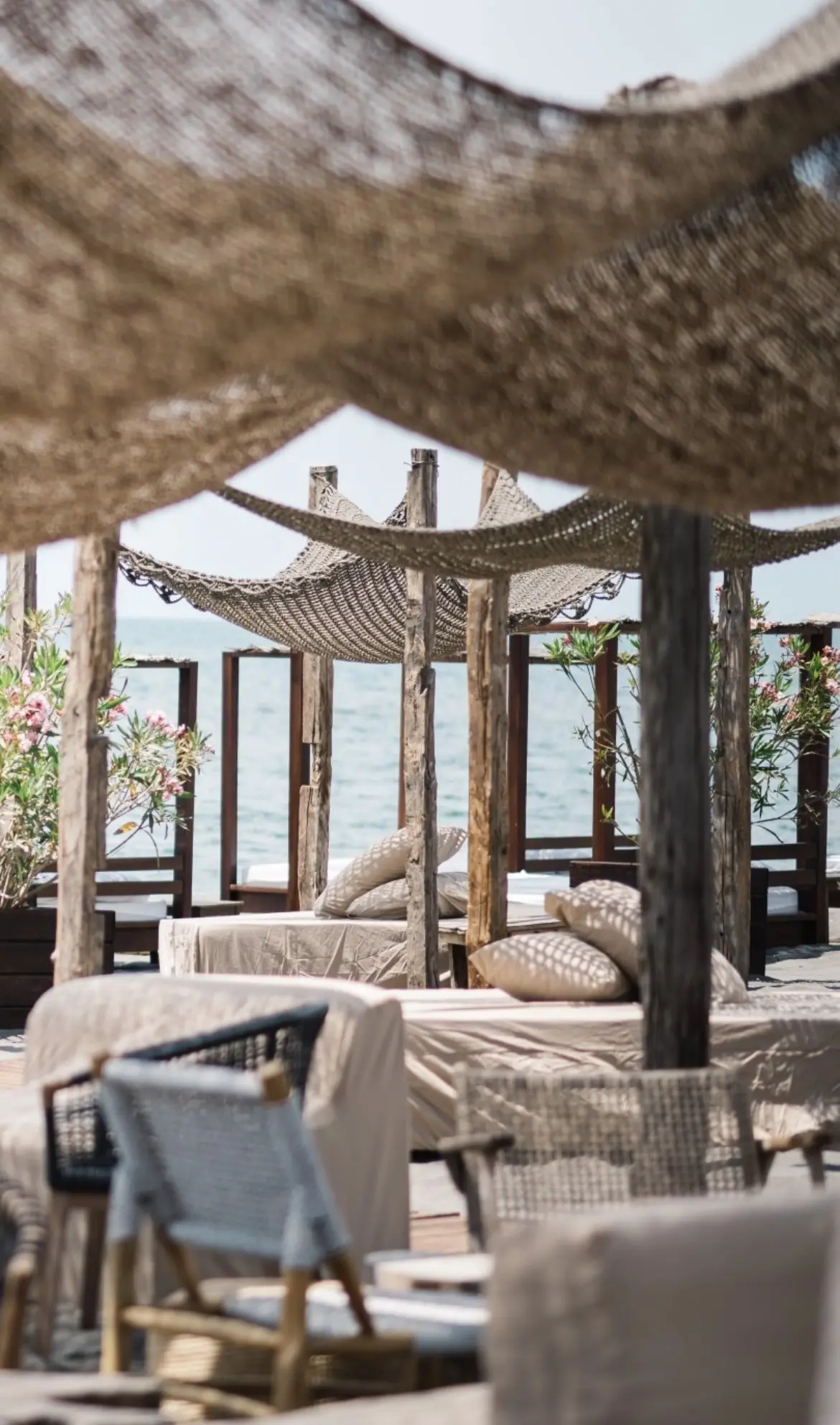 Reclaimed oak beams used as outdoor pergola posts beside a luxury terrace and waterfront setting