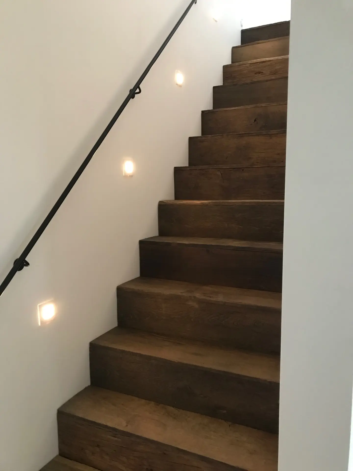 Custom wooden staircase with dark oak steps in a modern interior
