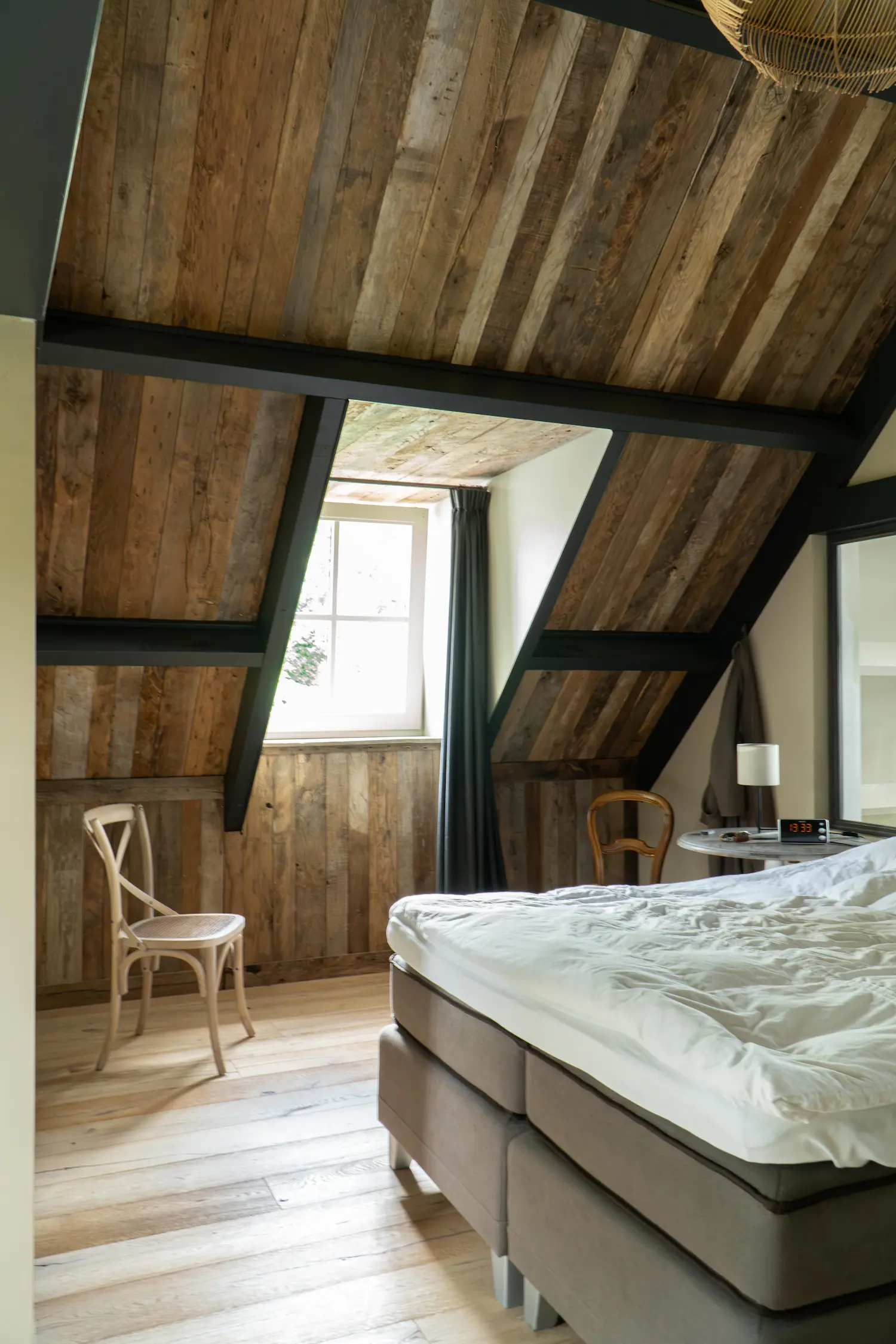 Bedroom interior with reclaimed wood wall panels and rustic aged timber finishes
