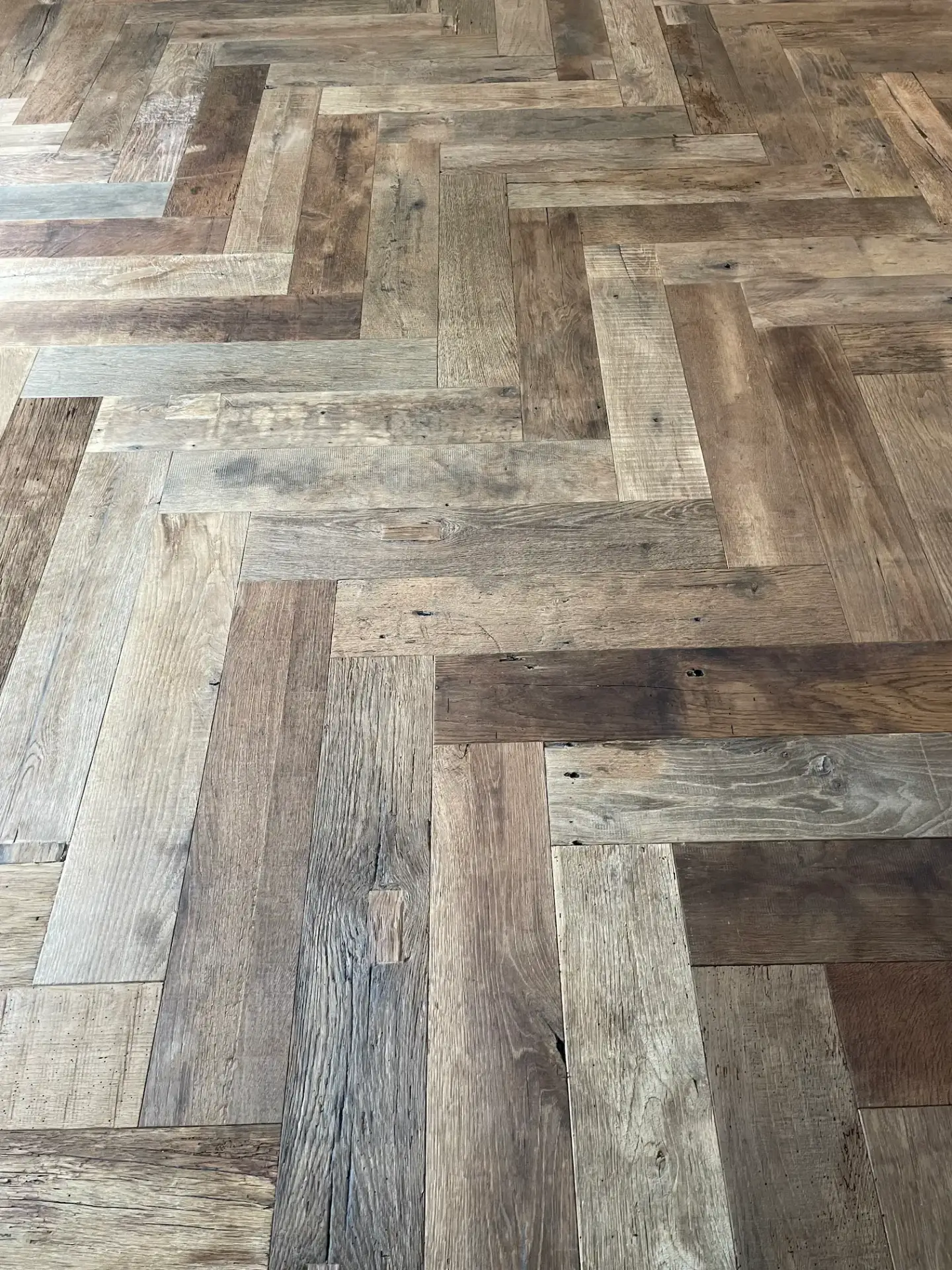Luxury reclaimed oak herringbone flooring with timeless parquet design and warm rustic appeal