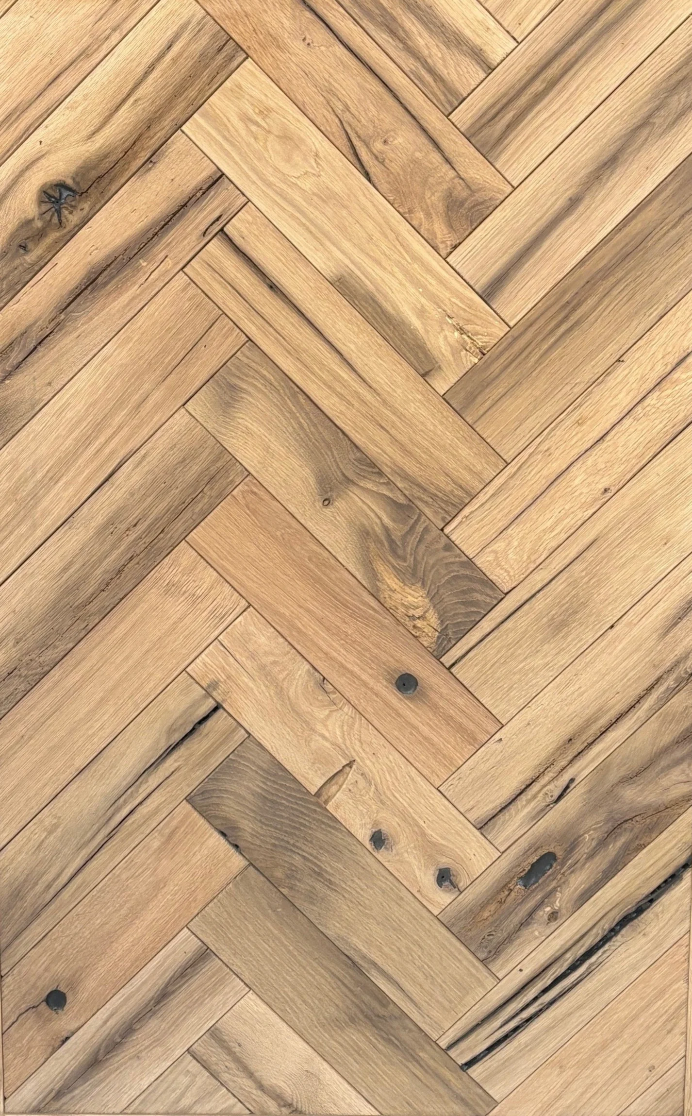 Premium reclaimed oak herringbone parquet flooring with handcrafted finish and warm oak colors
