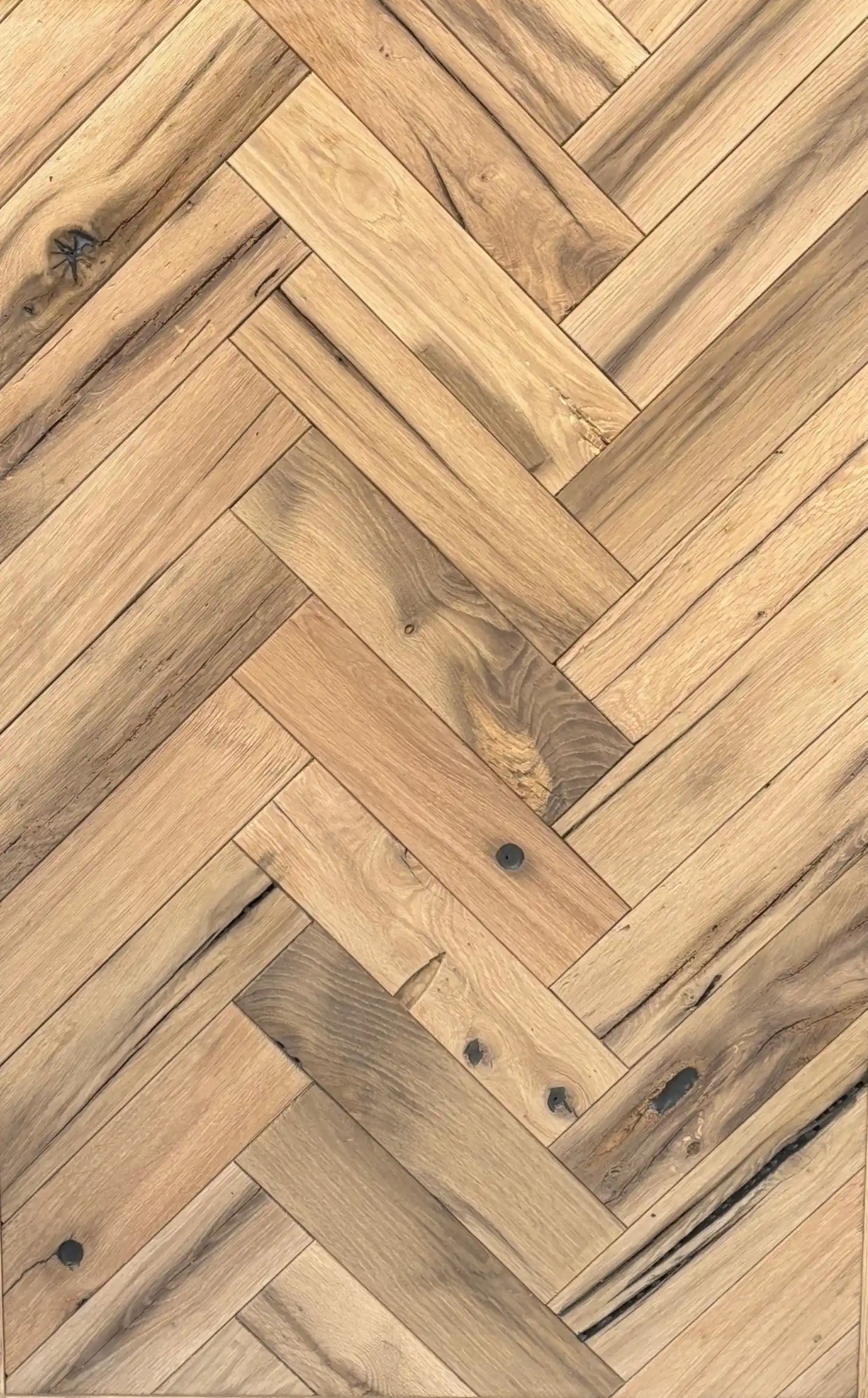 eclaimed oak herringbone flooring with warm natural tones and authentic wood grain patterns