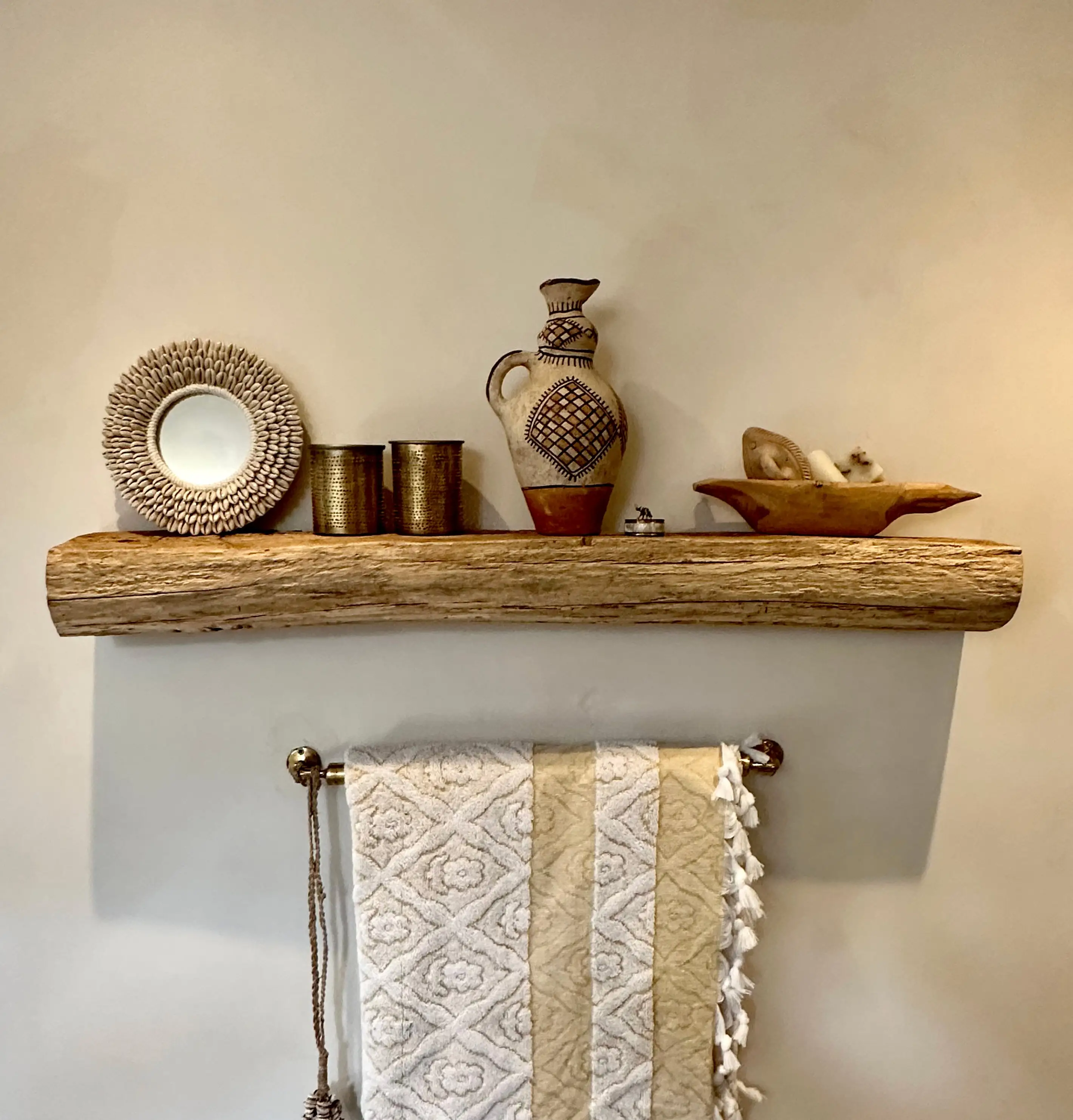 Rustic reclaimed wood shelves mounted on a tiled kitchen wall with exposed wooden beams