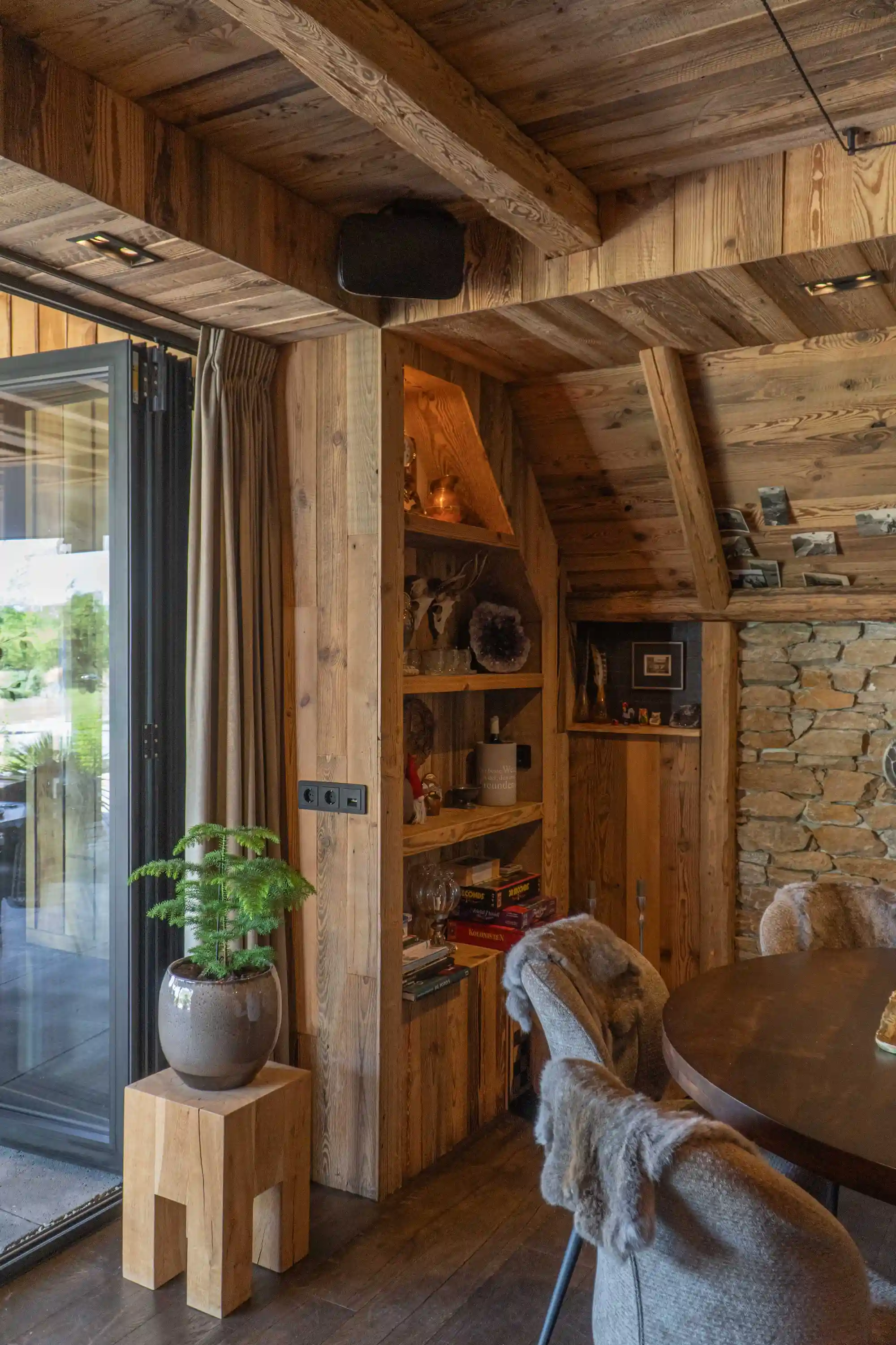 Reclaimed pine wall cladding and bespoke shelving create a warm and inviting garden room.