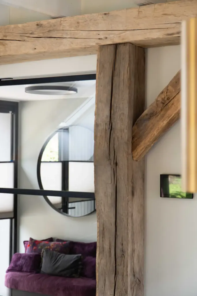 Reclaimed oak beams used as structural and decorative elements, adding warmth, texture, and authentic character to a modern interior.