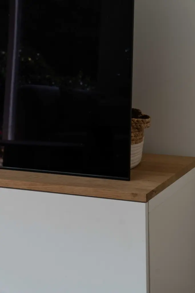Close-up of a custom TV unit finished with an antique oak plank, adding a warm natural detail to the interior.