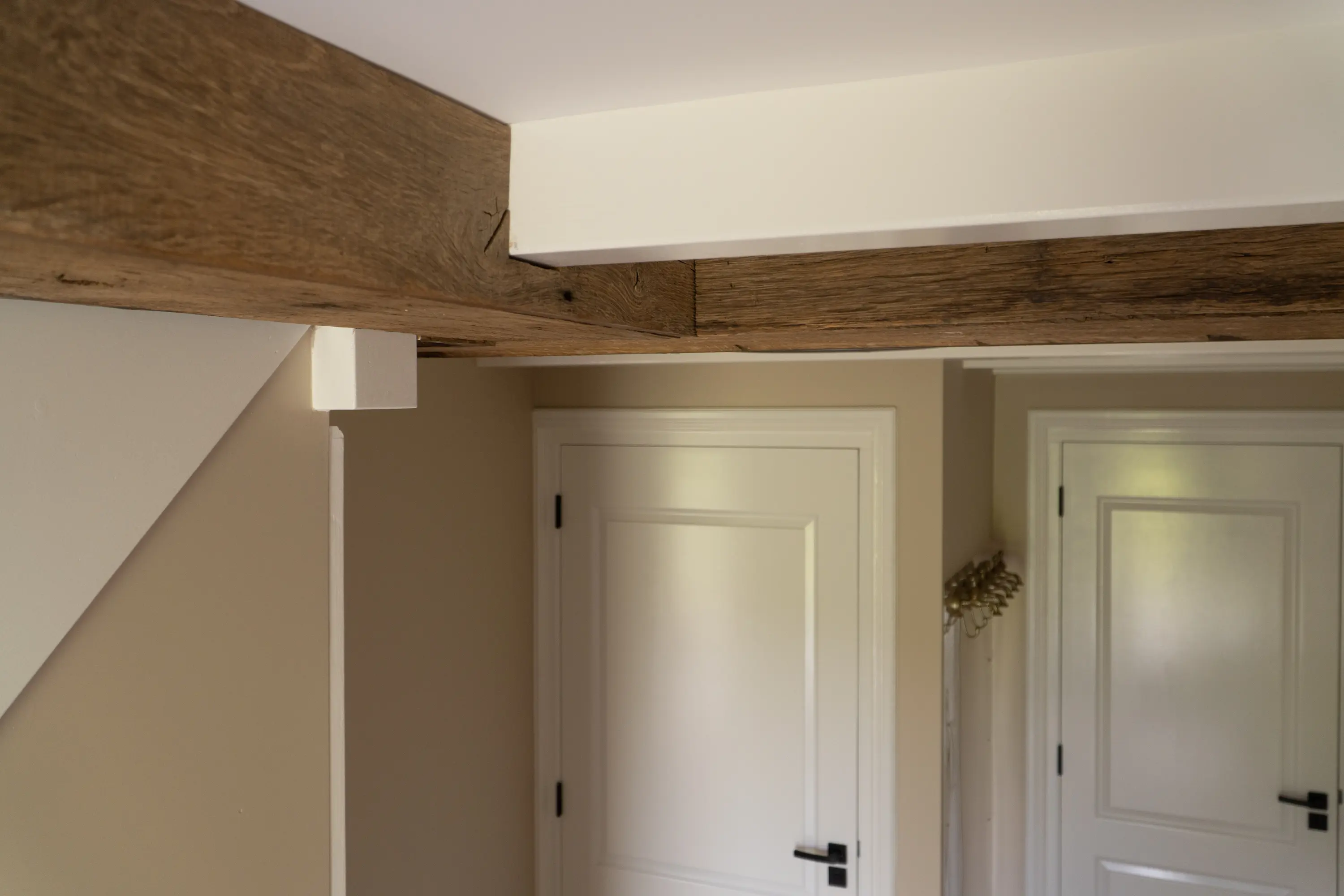Authentic reclaimed oak beam integrated above a doorway, adding warmth and natural character to the interior